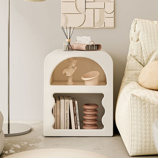cream bedside table with open shelves and books inside