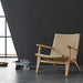 A sleek and elegant modern lounge chair made of rattan in a natural wood or walnut finish.